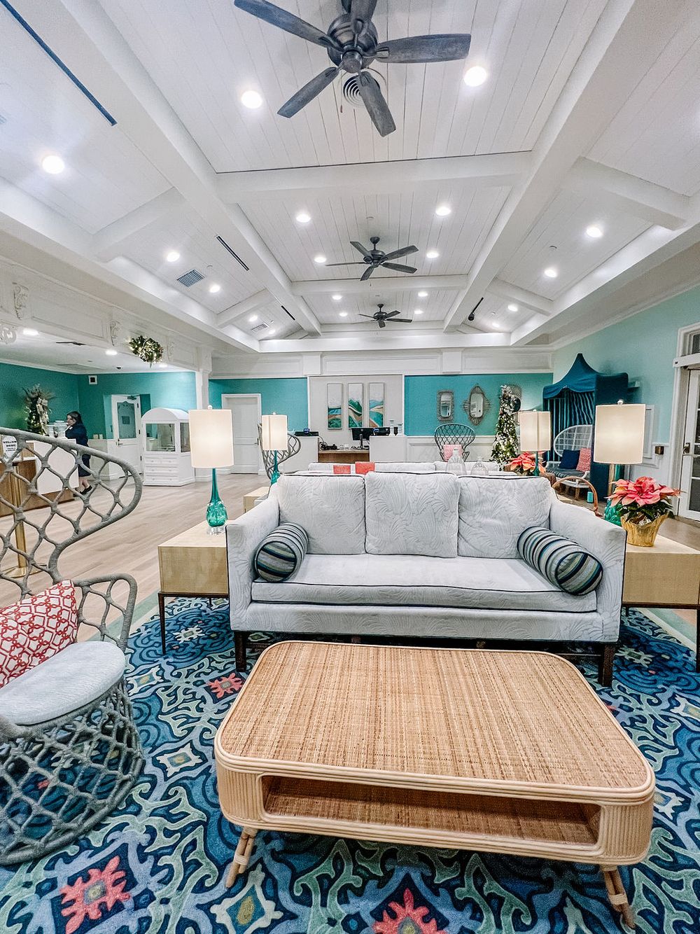 Modern living room with blue patterned carpet, light gray sofa, and wooden coffee table.