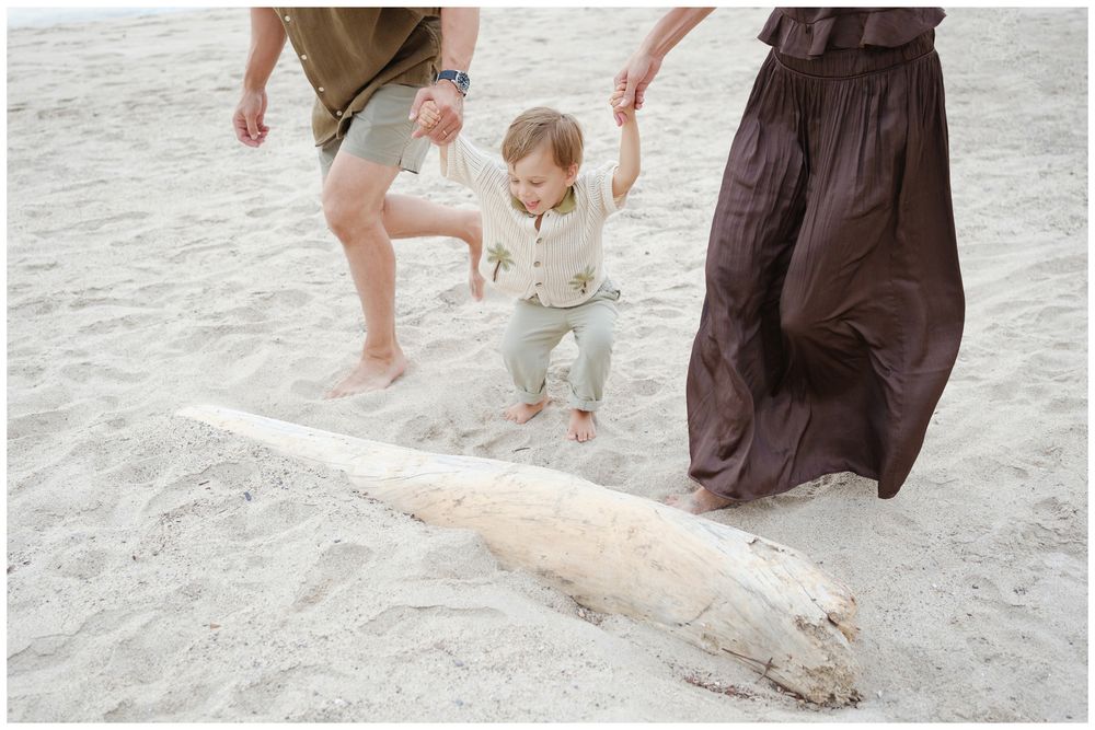 Child walking with parents during a Puerto Vallarta beach family photo session.