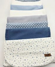 Stack of folded blue, gray, and white baby burp cloths with star and polka dot patterns.