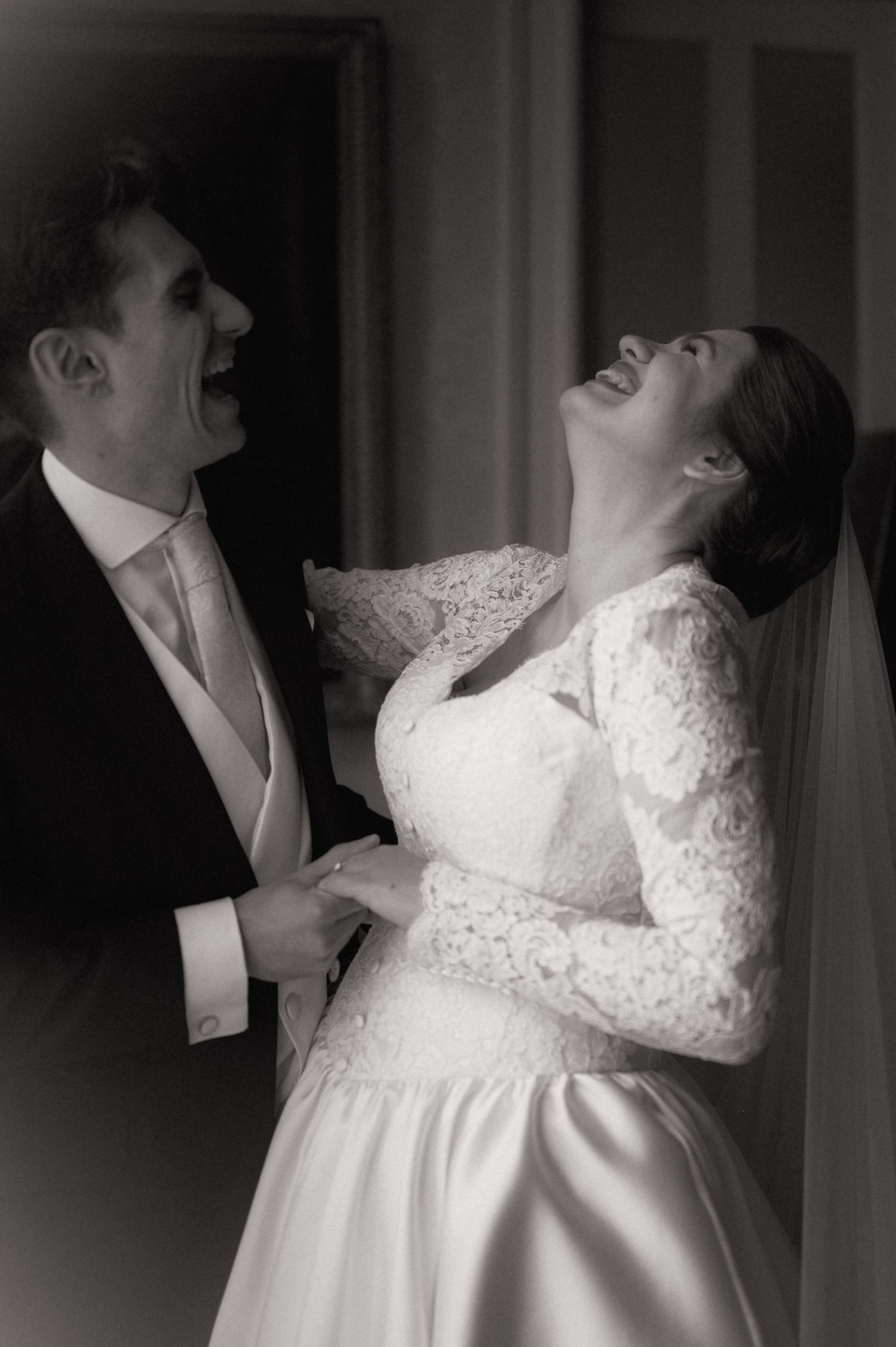 A bride and groom share a romantic kiss in an elegantly decorated room during their wedding ceremony.