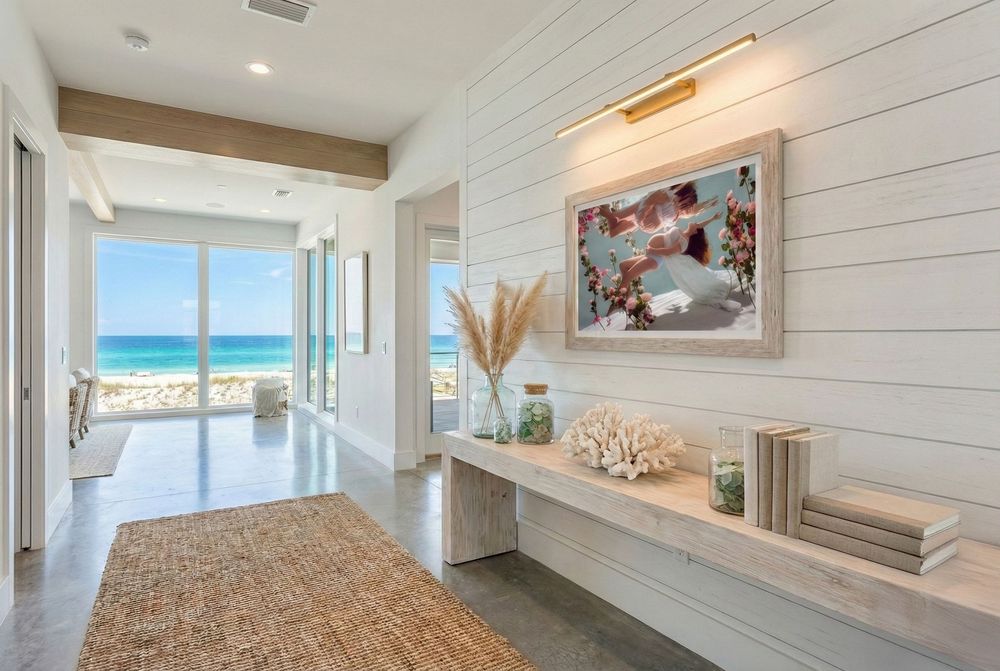 Coastal bedroom with shiplap walls features a panoramic ocean view through large windows and neutral coastal decor.