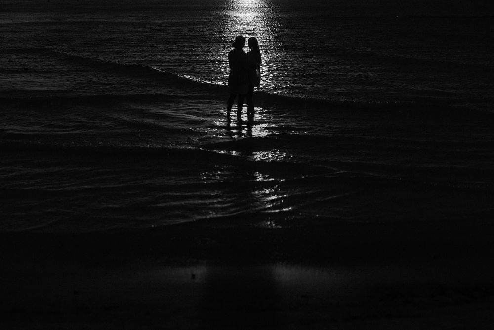 Two women embracing during an intimate surprise proposal at sunset on the beach in Holbox, Mexico.