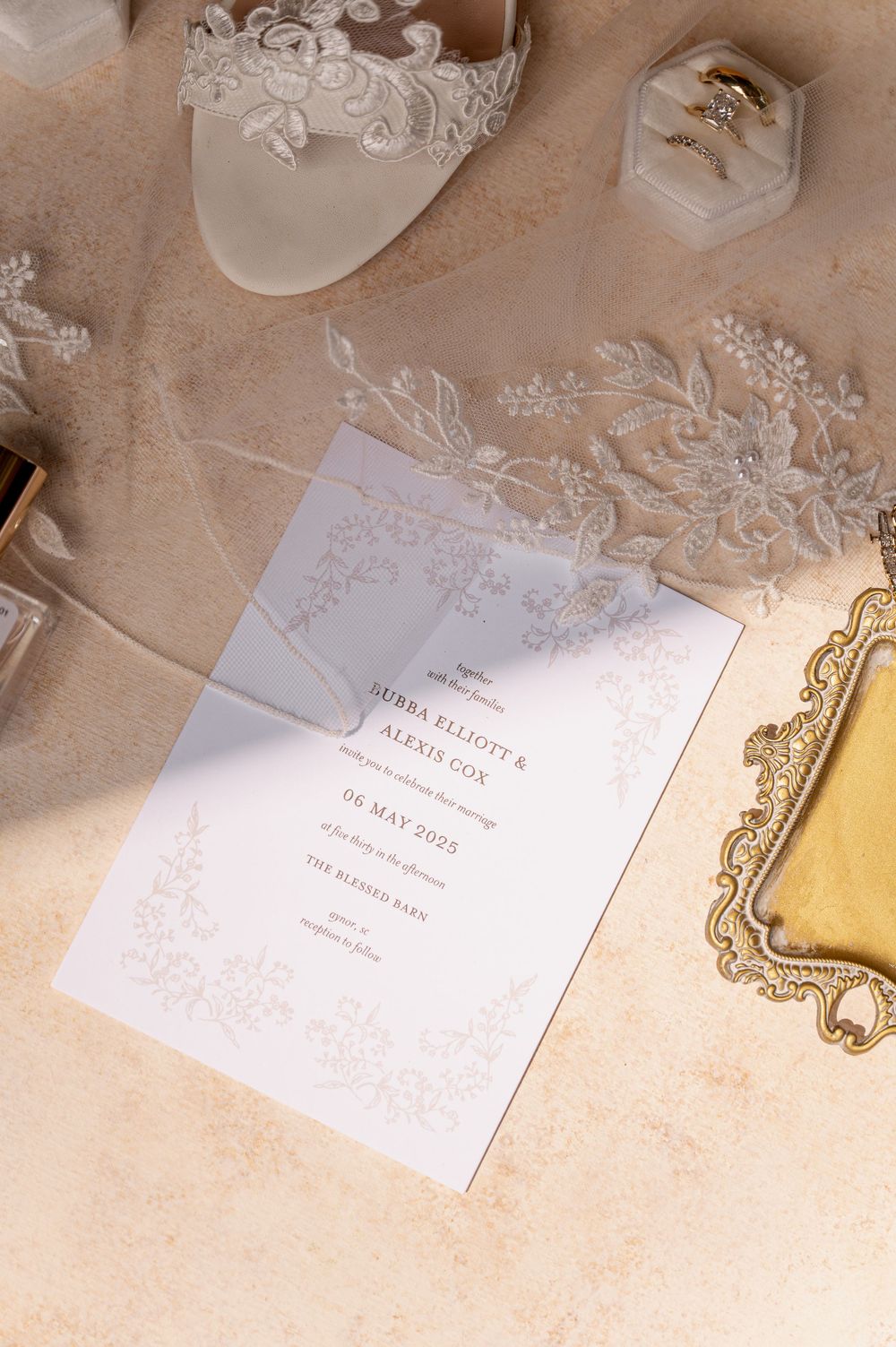 Wedding invitations and stationery laid out on a textured beige background with elegant details.