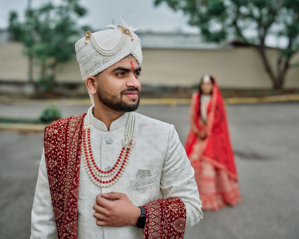 Traditional Indian wedding attire featuring red and white color scheme with elegant beaded necklaces and embroidered details.