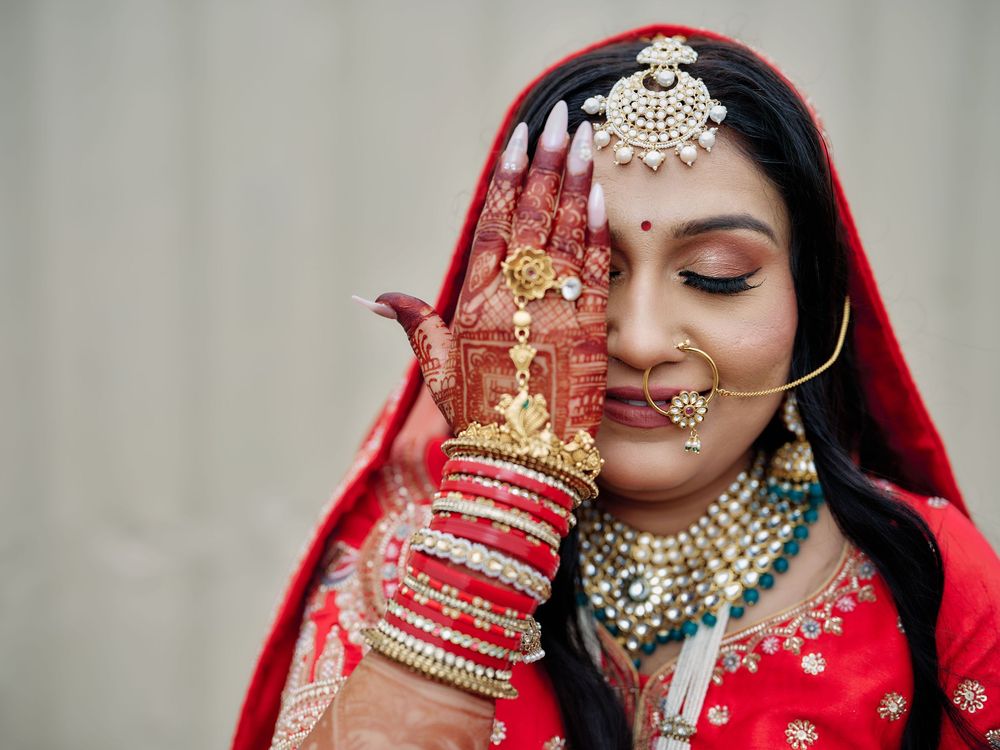Close-up details of Indian bridal jewelry and traditional red wedding attire.