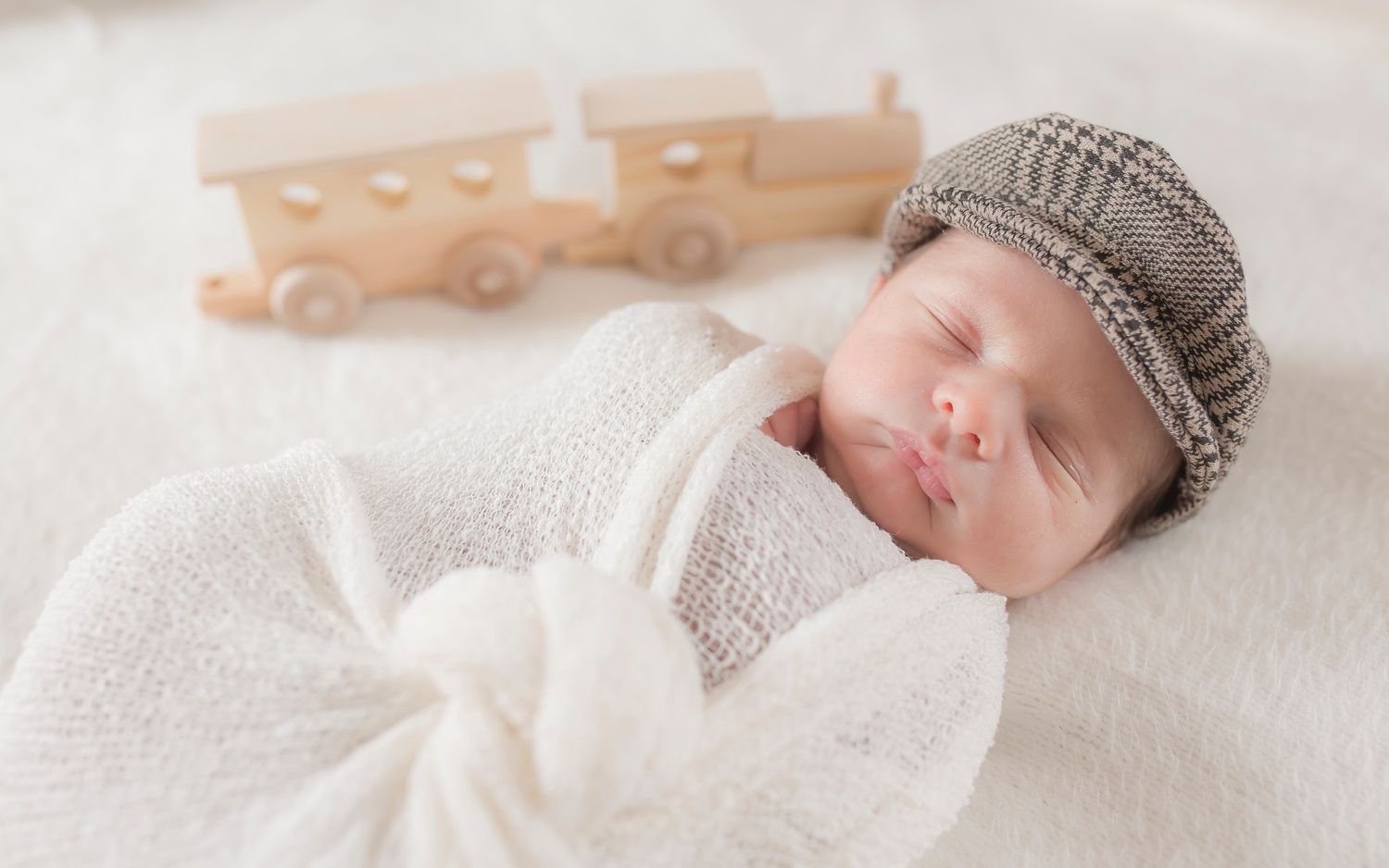 A series of soft, dreamy newborn photography portraits in neutral beige and white tones on textured blank