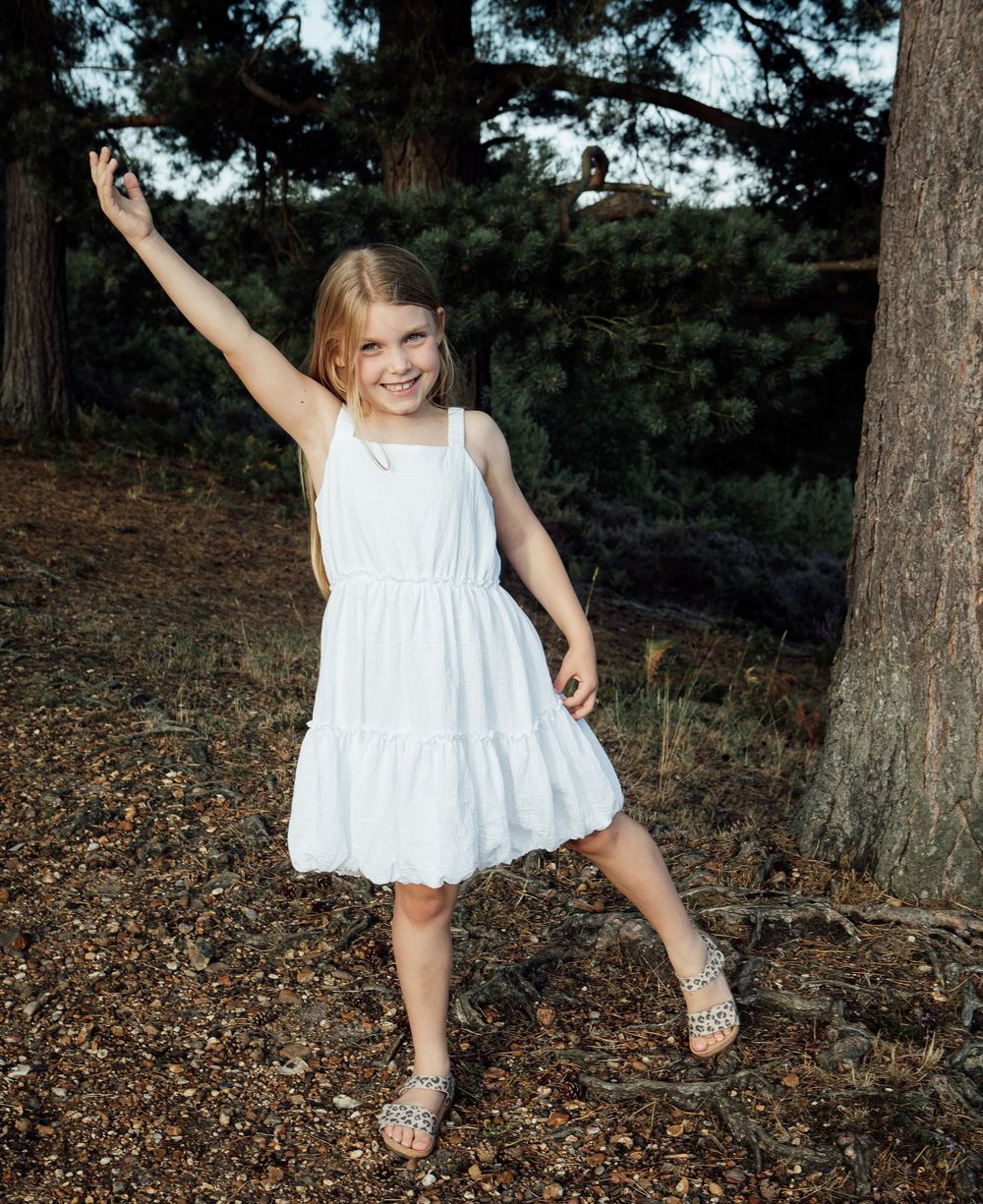 Young girl in a white dress enjoying posing for the camera.
