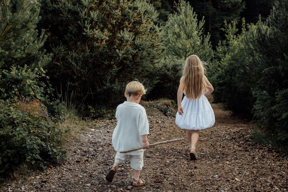 Photo of the young brother and sister walking away from the camera down a hill at the end of the shoot.