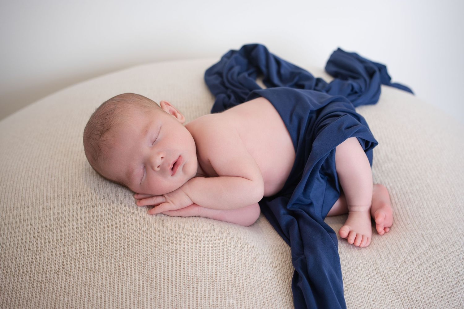 Newborn boy side pose on beanbag with blue wrap — newborn photography near Devizes