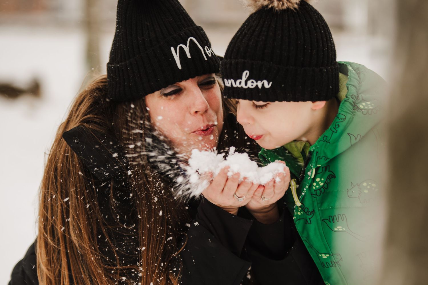 A romantic couple kisses in a snowy winter setting with green lighting creating a magical atmosphere.