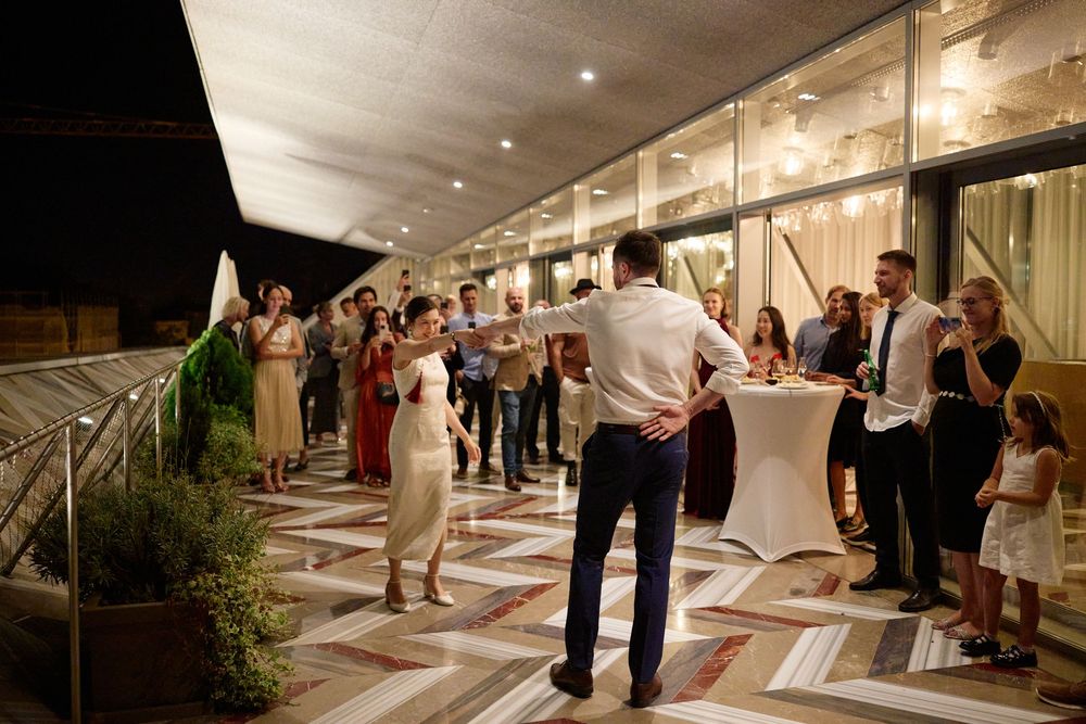 Indoor wedding reception venue with guests mingling under soft lighting.