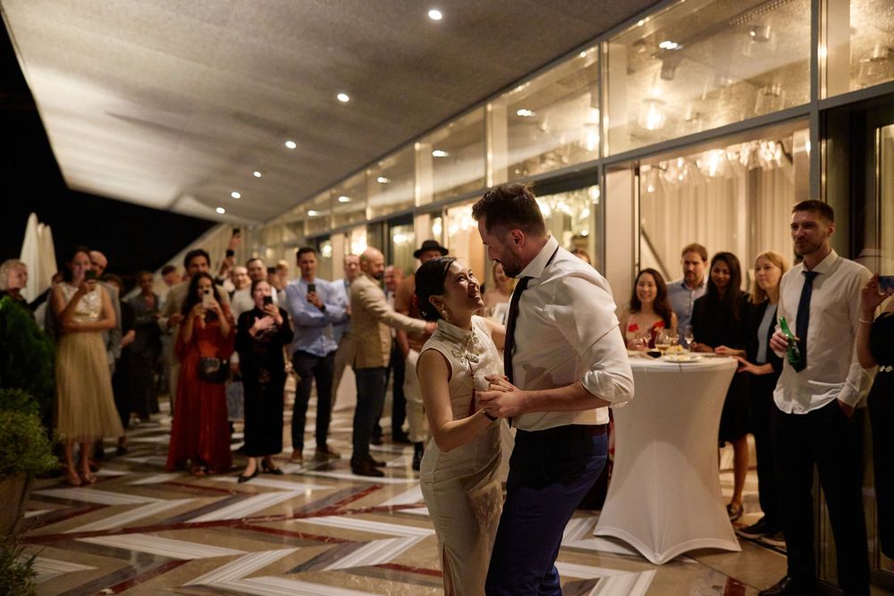 Wedding reception venue with guests mingling in an elegant indoor space with ambient lighting.