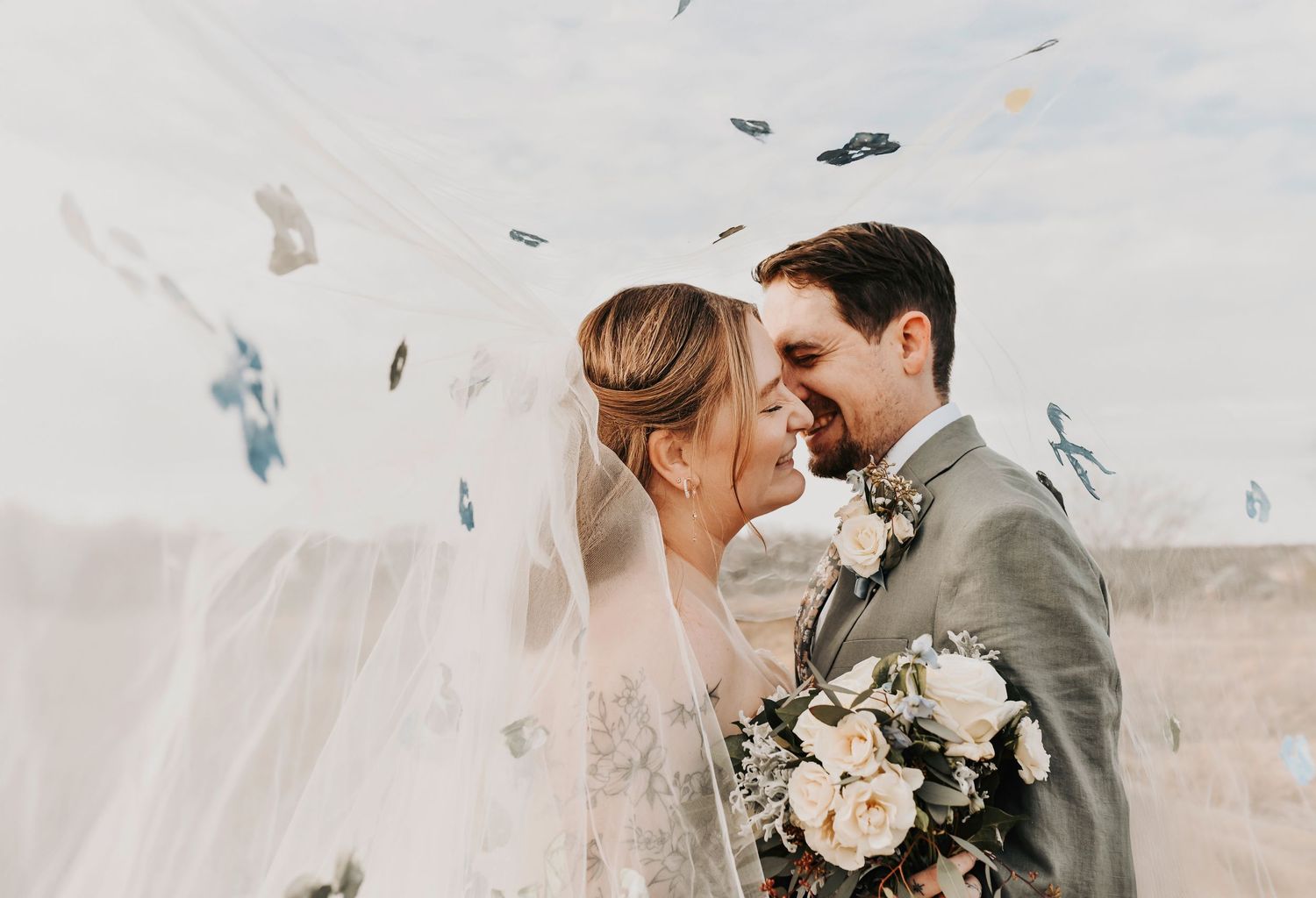Bride and groom kissing beneath a cathedral veil during romantic winter wedding portraits at The Dalmore Event Venue