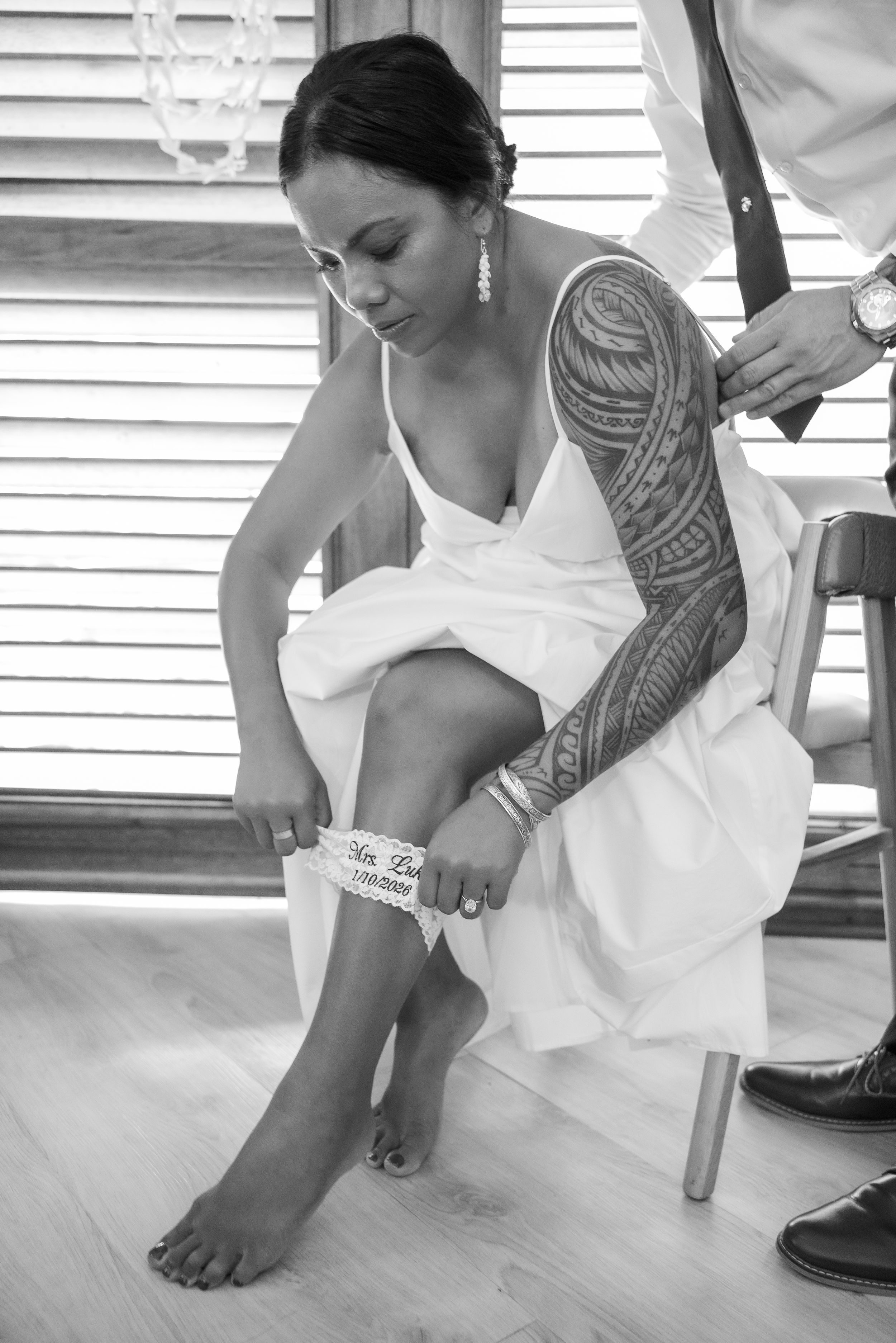 Series of black and white photos showing a wedding dress being adjusted and fitted near the floor.