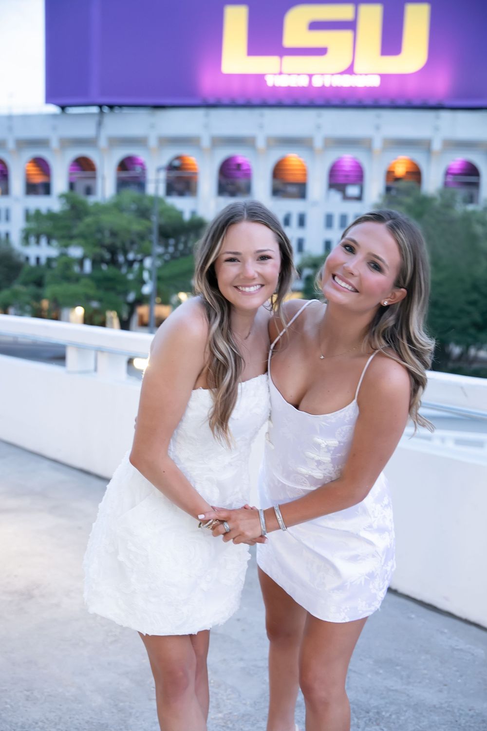 Tri Delta Roommates taking graduation pictures together in front of LSU Marquee.