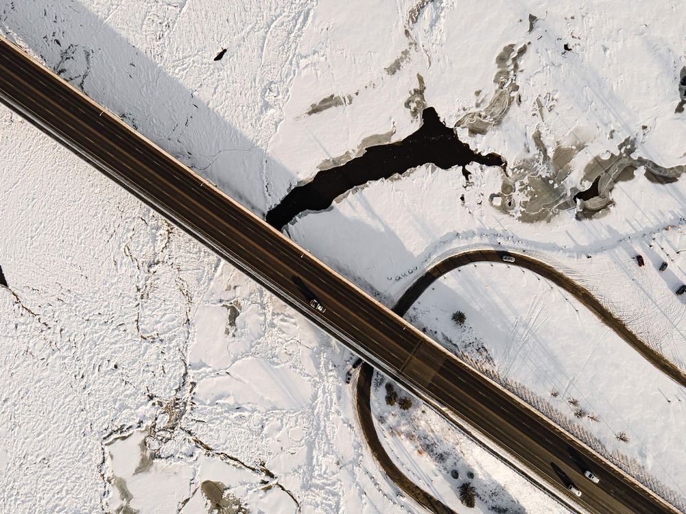Abstract patterns of snow and shadows creating geometric lines across a winter landscape.