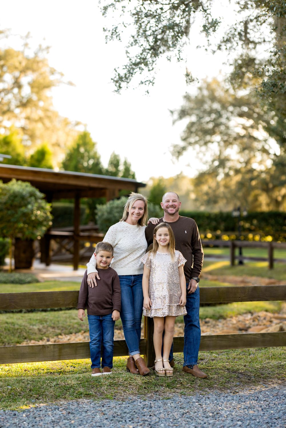 Family enjoying a casual outdoor photo session in a park during golden hour.