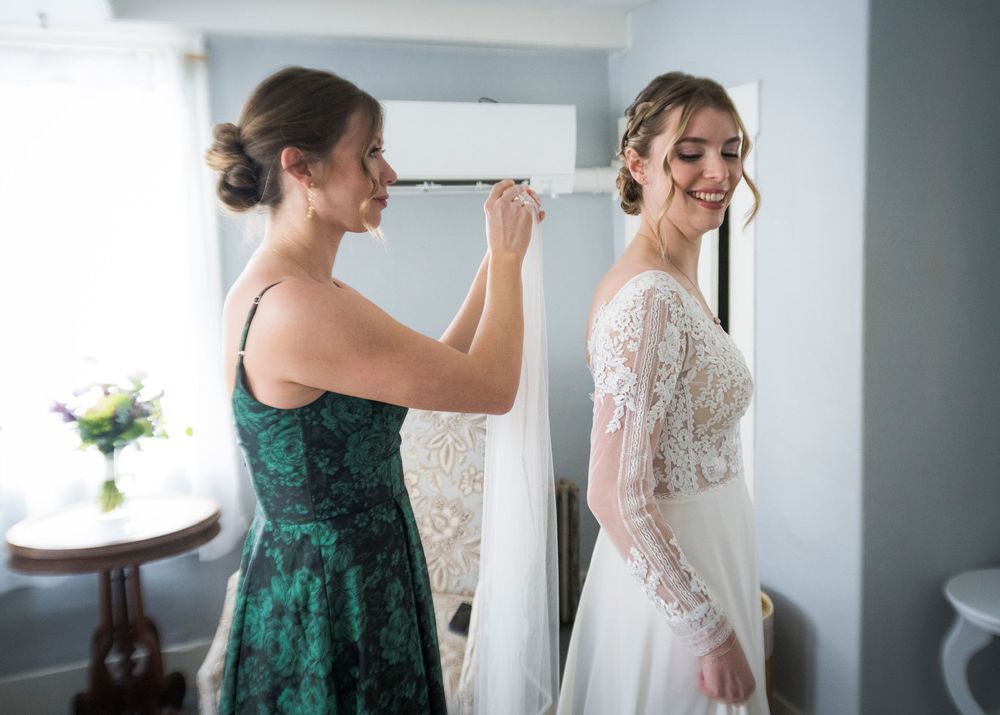 Wedding preparation scene with elegant white dress and formal attire being readied in a bright room.