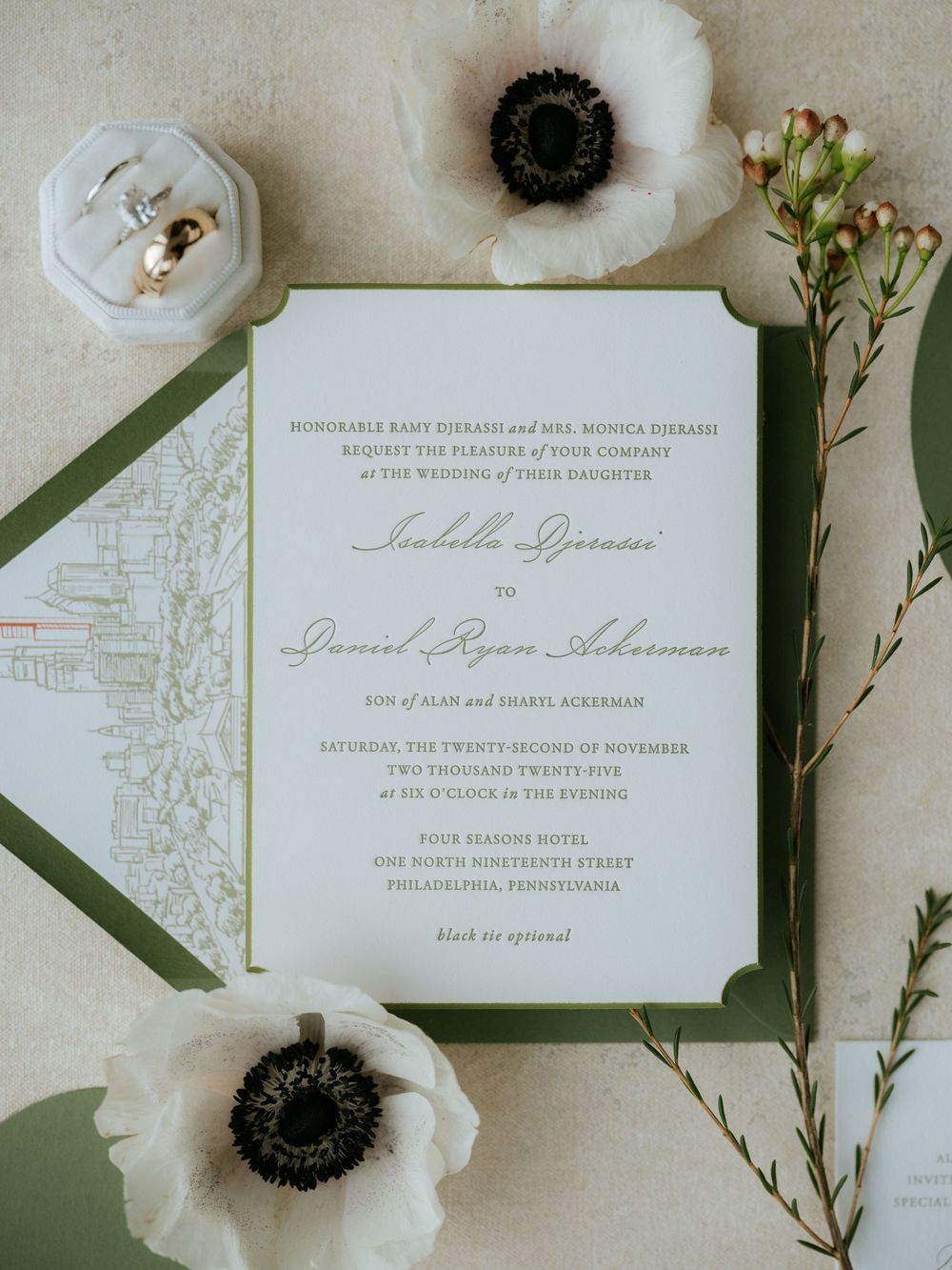Elegant wedding invitations in sage green and white with delicate anemone flowers and greenery as styling elements.