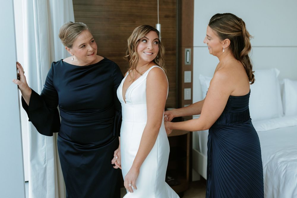 A series of wedding party photos showing people in navy blue and white dresses preparing in a bridal suite.