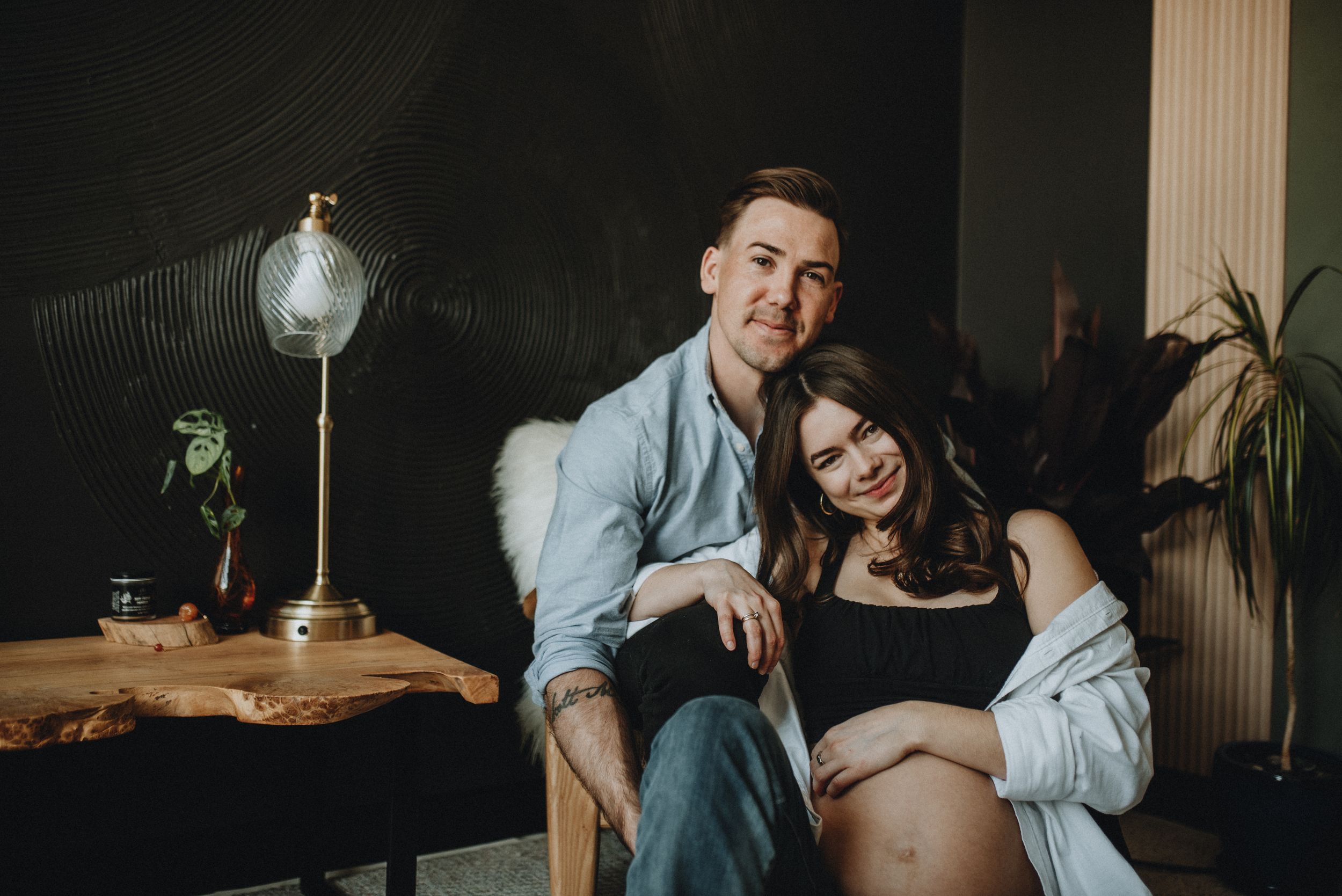 a couple embrace  together during this maternity shoot in Cochrane Alberta