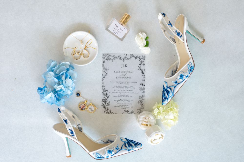 Delicate white and blue paper butterflies arranged with wedding invitation cards and decorative elements on light surface.