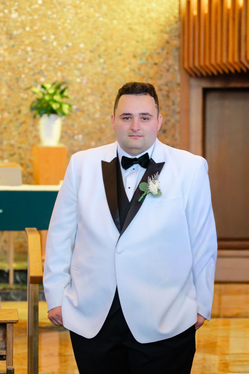 Groomsmen in white tuxedo jackets and black bow ties pose for formal portraits.
