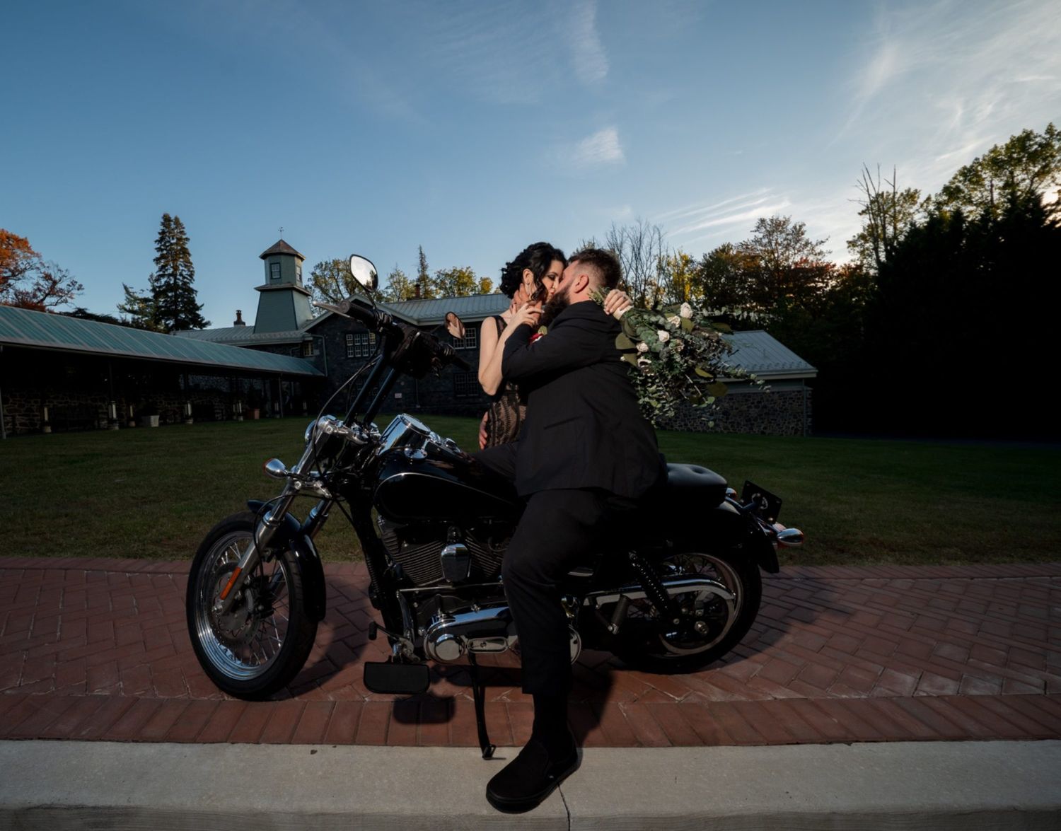 Bride and groom kissing on a motorcycle during sunset portraits at a Delaware wedding