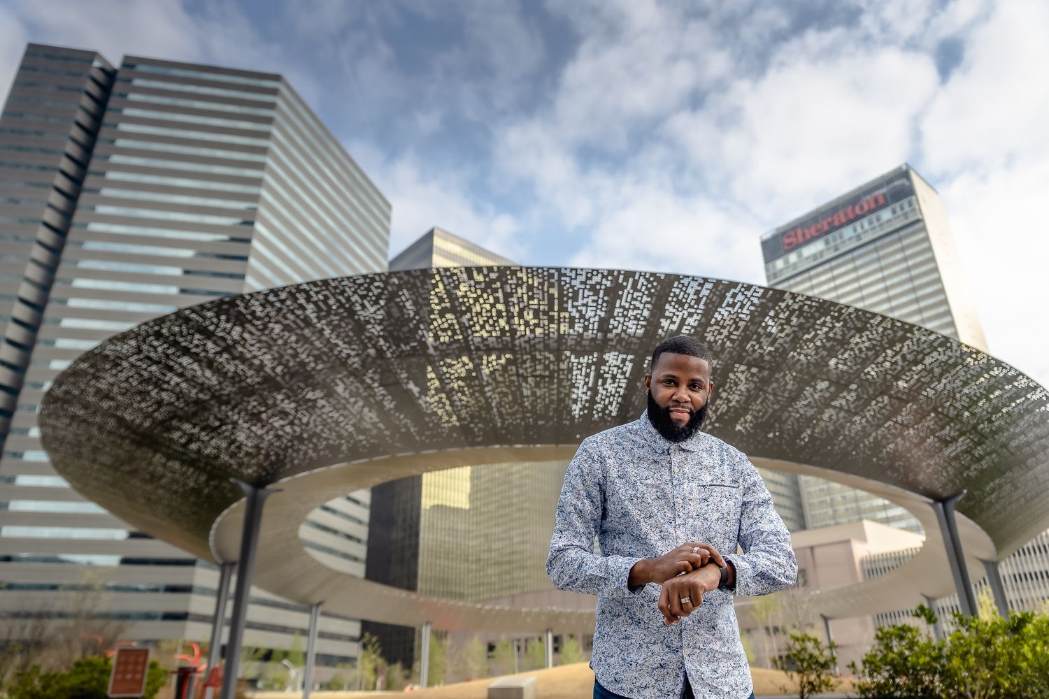 Person standing beneath modern architectural canopy structure in urban setting.
