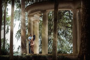 Romantic couple photo session in outdoor garden colonnade with classical architecture.