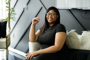 Professional indoor photography session with two people sitting on a white couch.