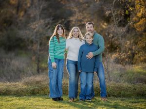 Family portrait session in autumn field with golden light.