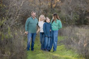 Casual family photo shoot in natural outdoor setting.