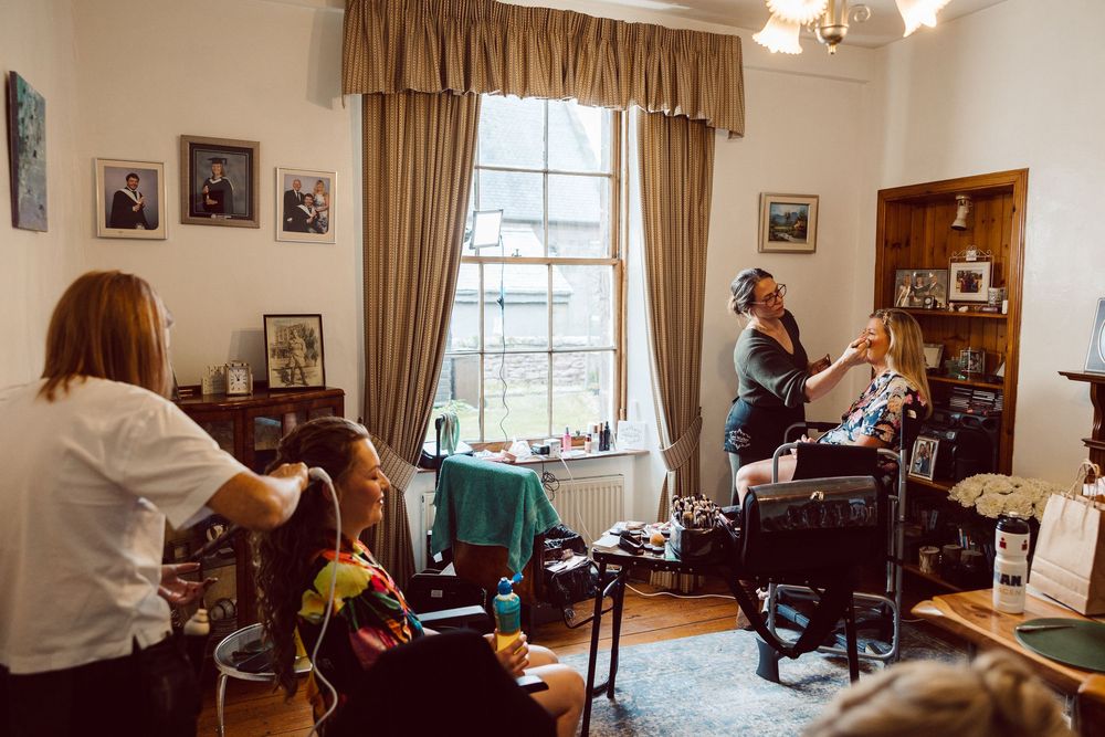 A panoramic view of a cozy living room interior with traditional furniture, window light, and warm brown decor.