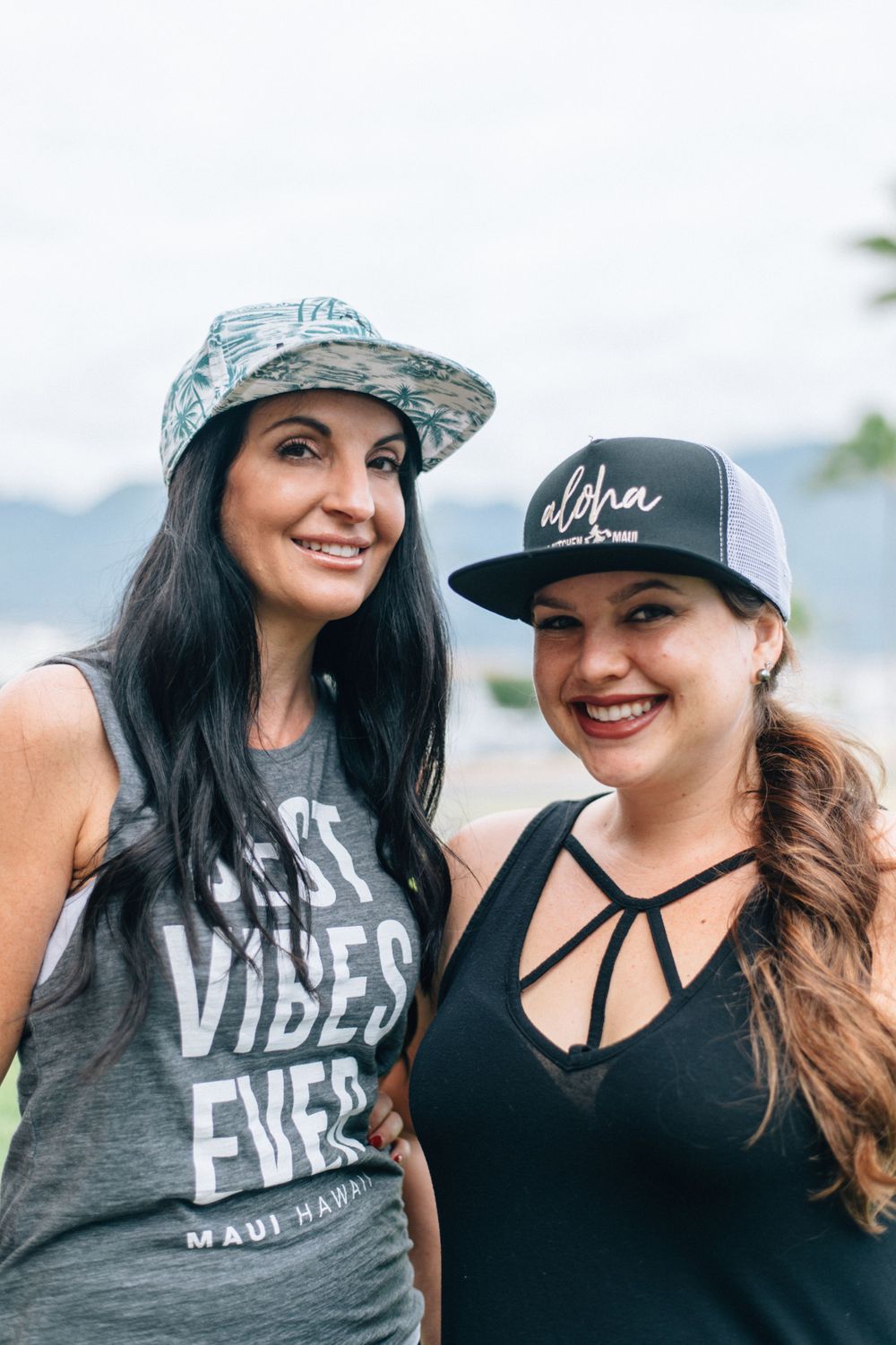 Two friends wearing casual graphic t-shirts and hats outdoors.