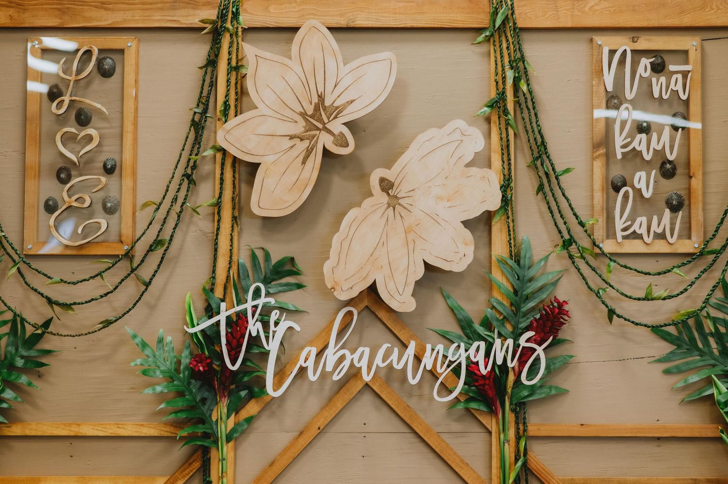Wedding reception decor featuring bamboo elements and floral wall decorations.