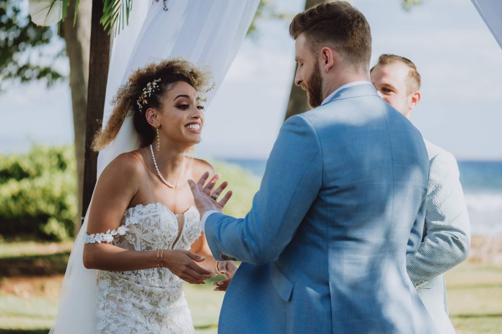Emotional moments shared during a seaside wedding ceremony with tropical backdrop.