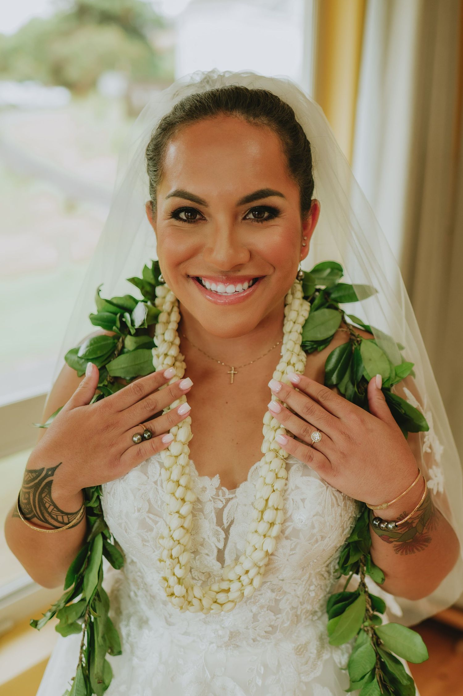 Traditional Hawaiian bride wearing white dress and lei necklaces.