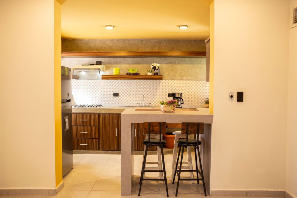 Modern apartment interior with warm lighting showcasing kitchen and dining area.