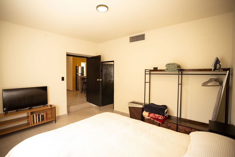Panoramic view of a modern minimalist apartment interior with white walls and hardwood floors.