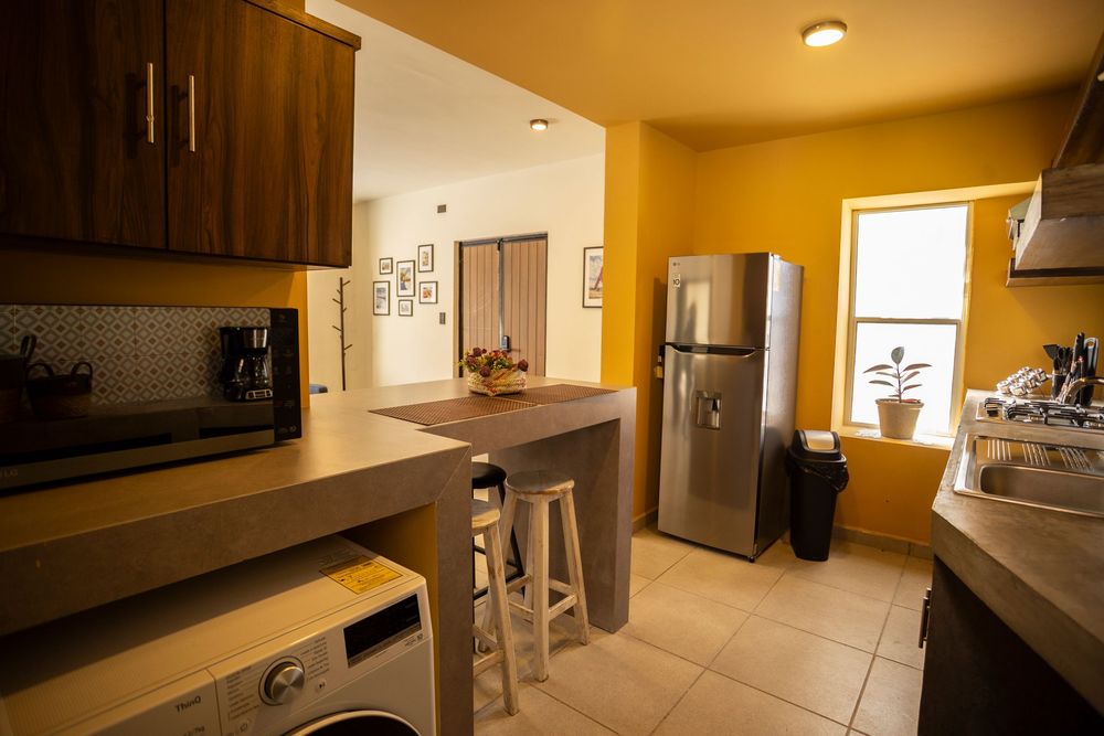 Empty apartment kitchen interior with beige walls and recessed lighting.