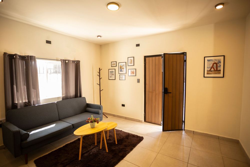 Spacious room interior with dark leather couch and warm lighting featuring minimalist decor.