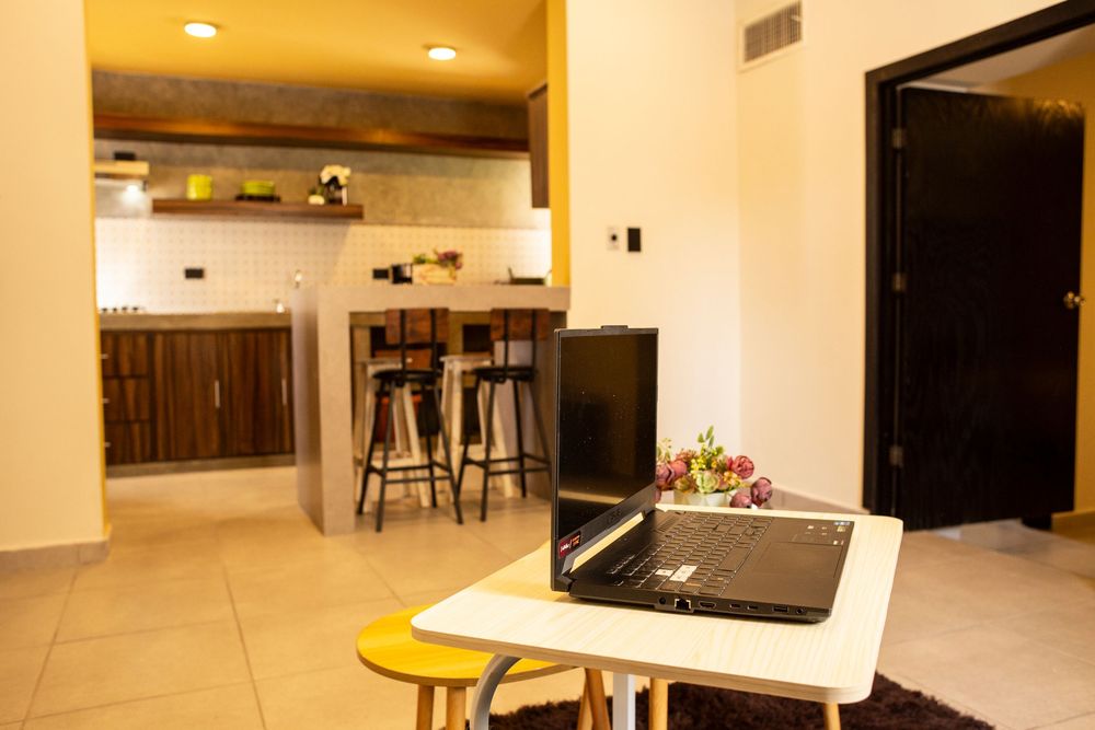 Modern apartment interior with recessed lighting and open concept layout showing kitchen and living areas.