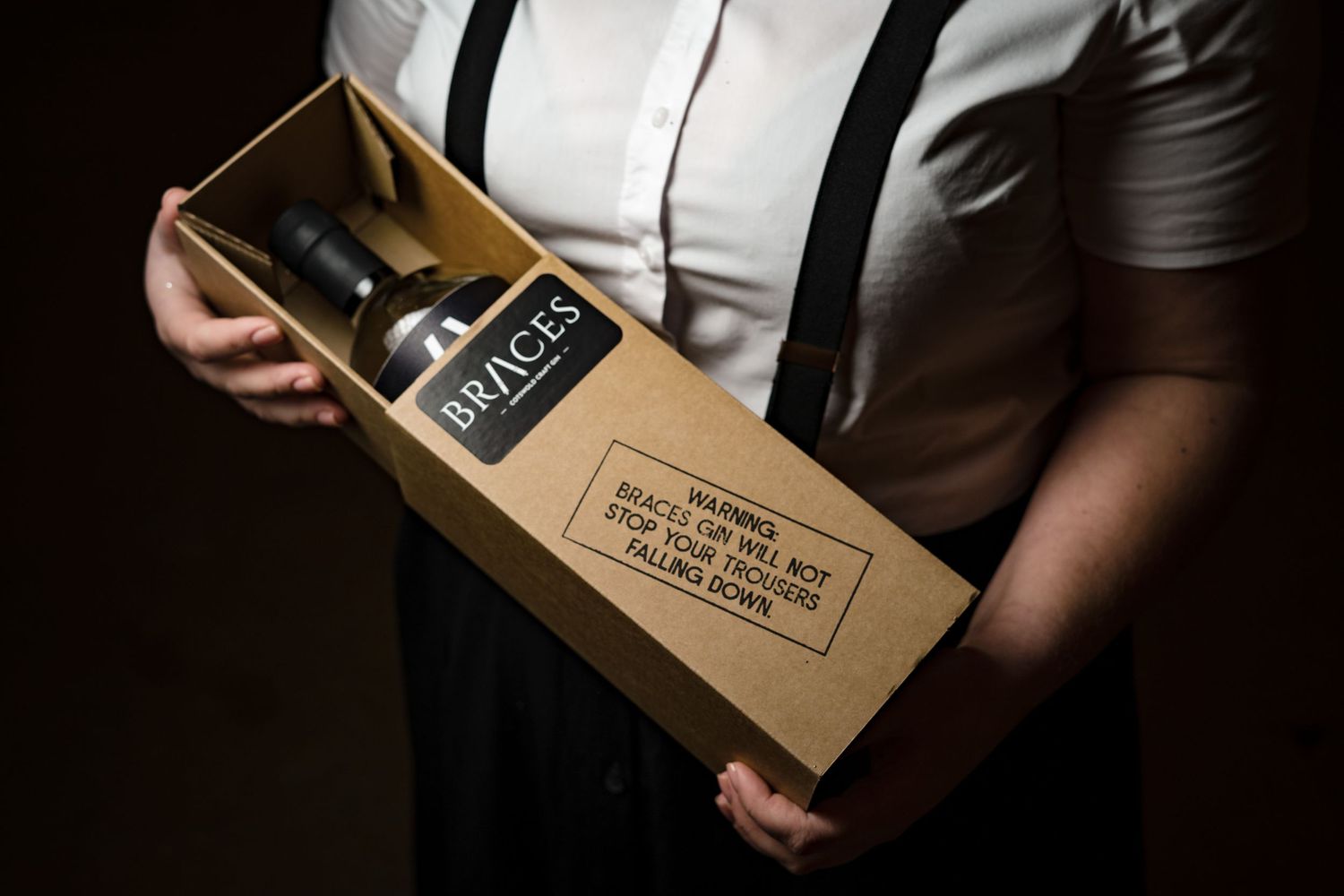 Braces gin gift box held by bartender for premium spirits brand photography