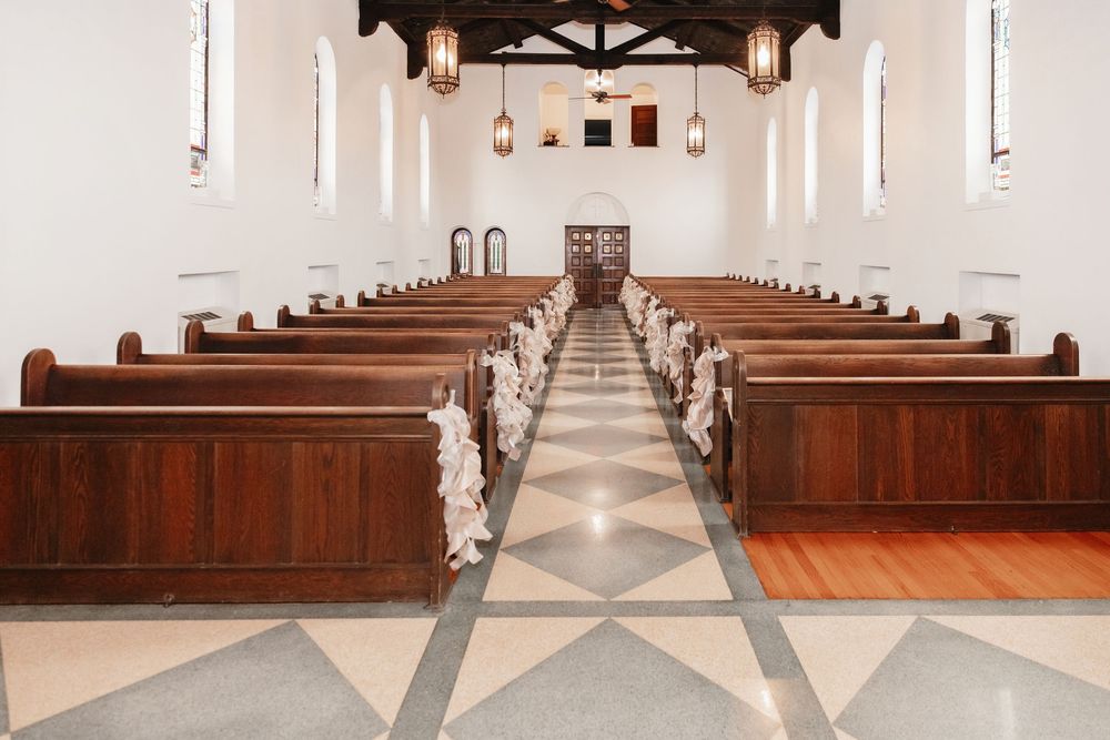 Interior view of an elegant church sanctuary with wooden pews and a center aisle leading to the altar.