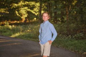 Tween boy giving a confident expression while posing on his Harford County Maryland wooded driveway for L Buchanan Photography