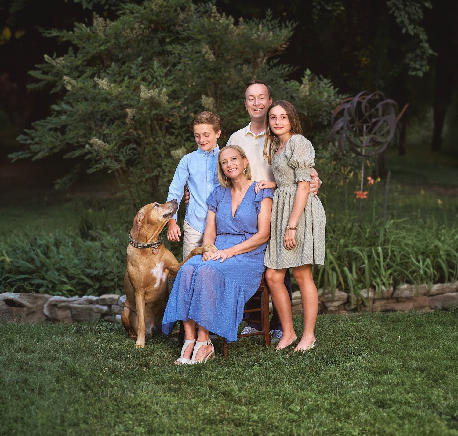 Family of four and their loyal dog posing in their Harford County MD back yard in a summer photo session