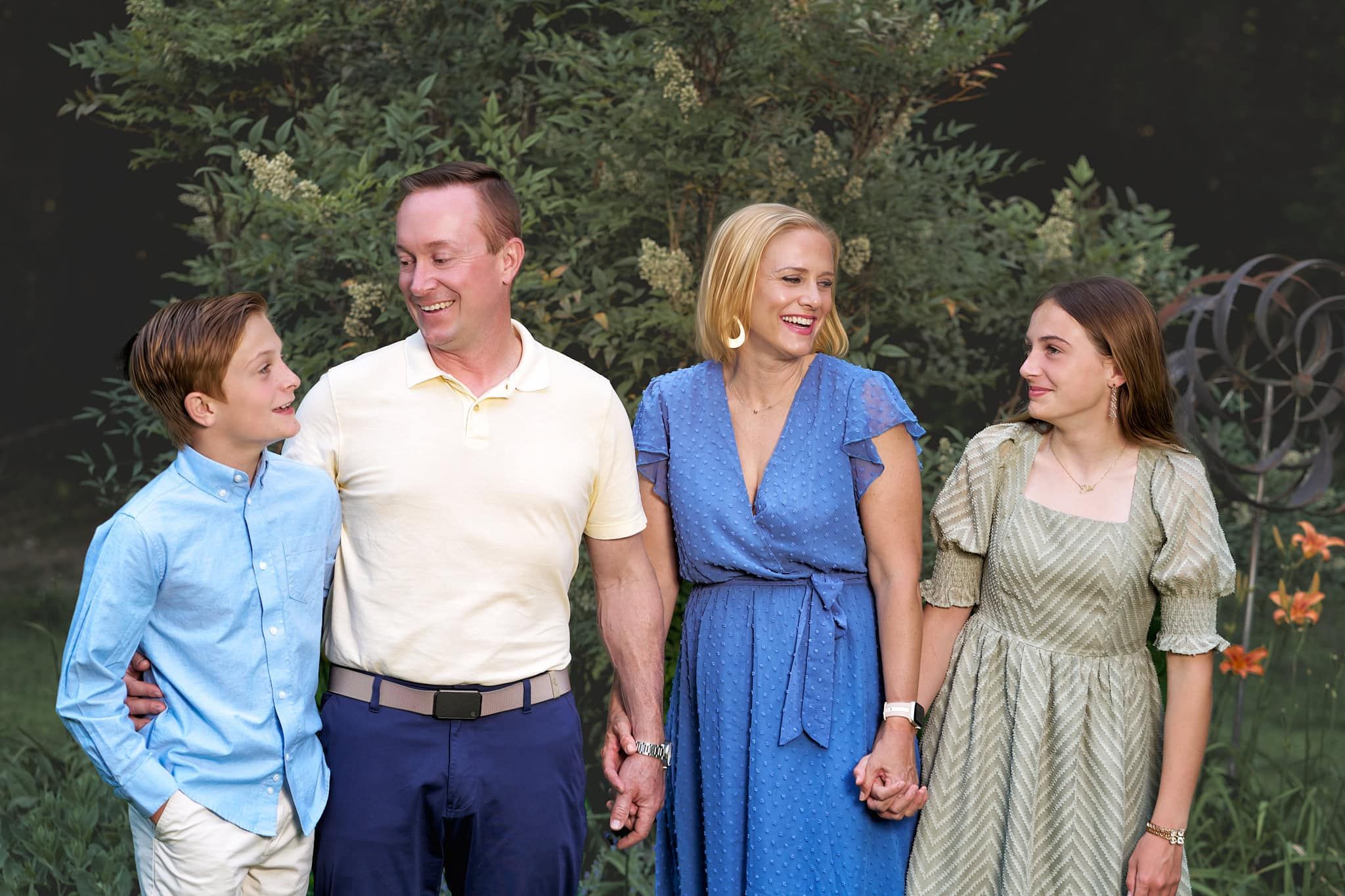 Joppa MD parents glancing admiringly at their tween son and teen daughter in the garden