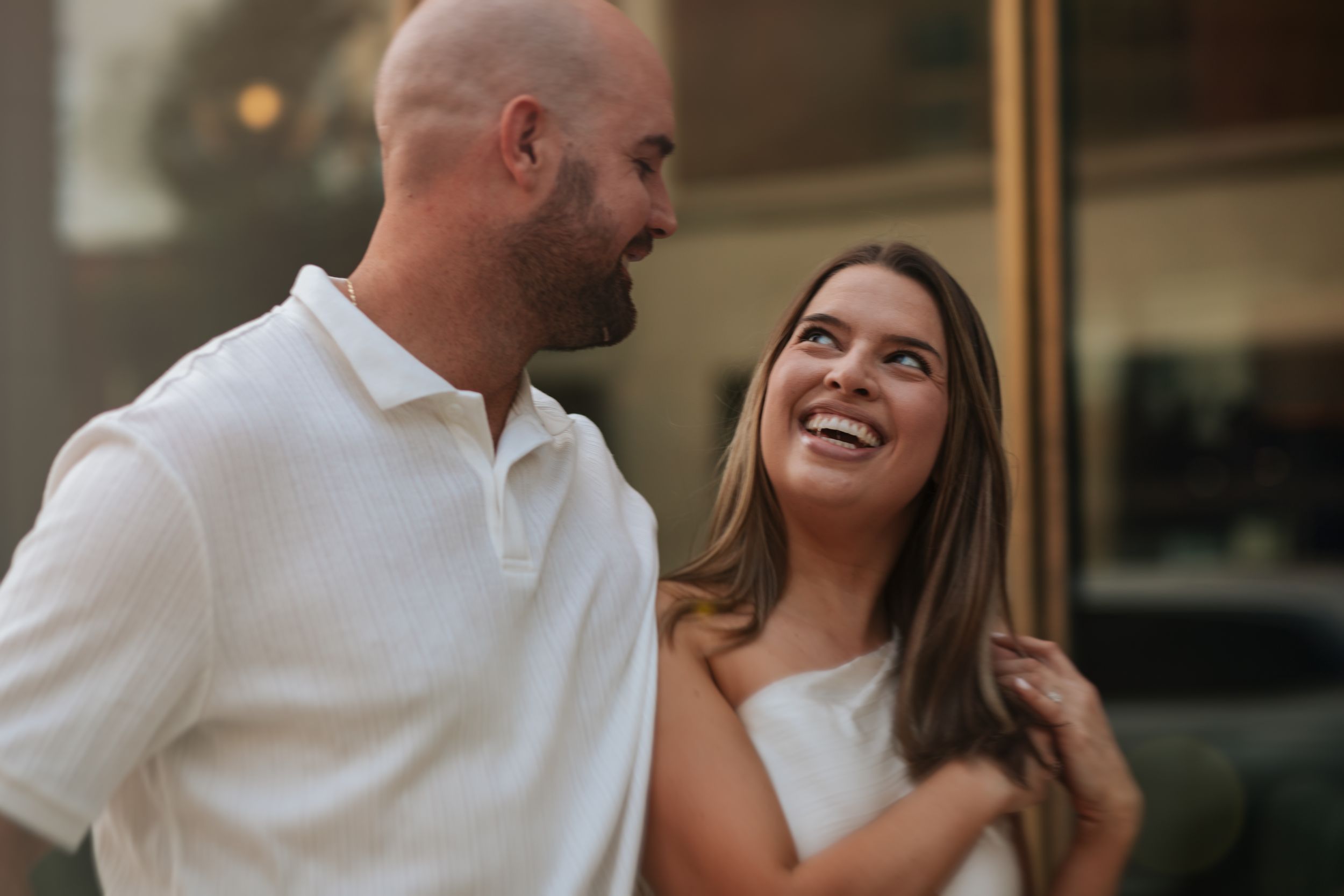 Happy couple sharing a joyful moment while walking outside a building.