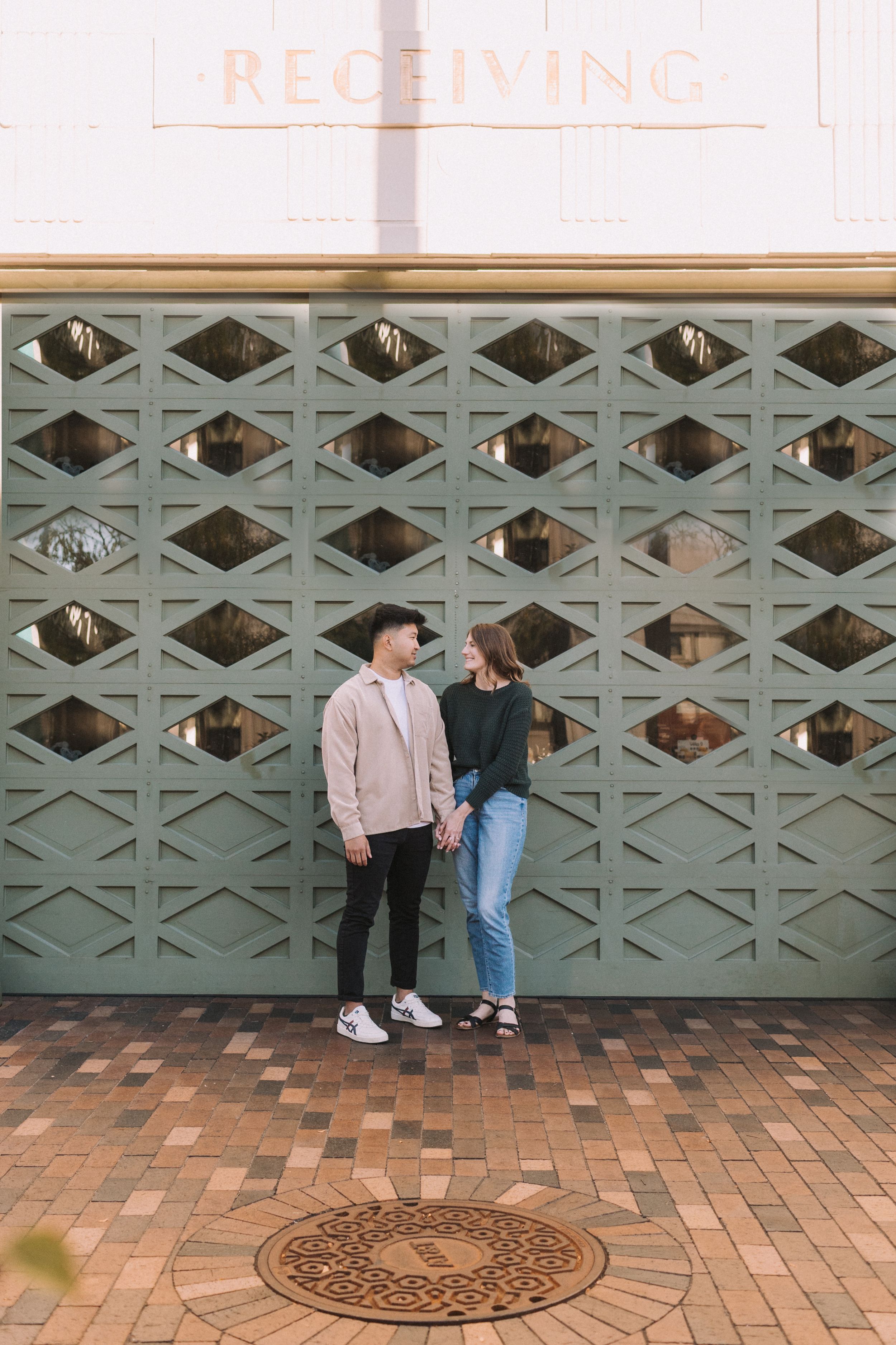 Four sequential photos showing people sitting against a teal geometric wall with brick pavement and a manhole cover.